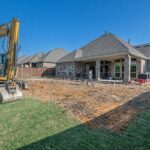 A construction site for a new patio in a Texas backyard with heavy machinery.