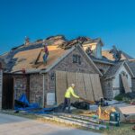 Workers engage in roof replacement on a brick house in Fort Worth, Texas.